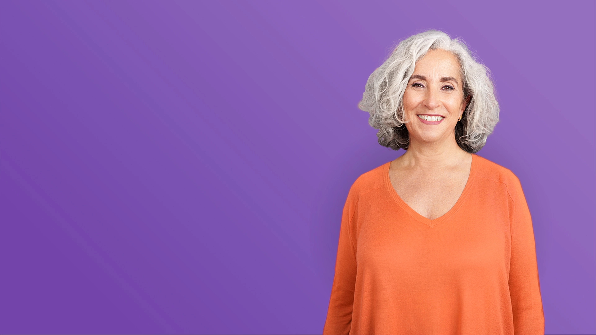 Smiling older woman purple background
